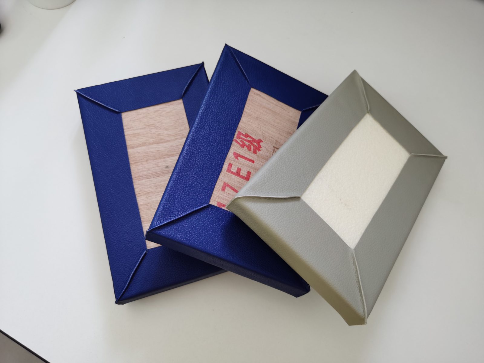 皮革包覆防撞软包墙板样品,背面展示E1级木板底板与高密度海绵结构,适用于办案区审讯室防撞装修