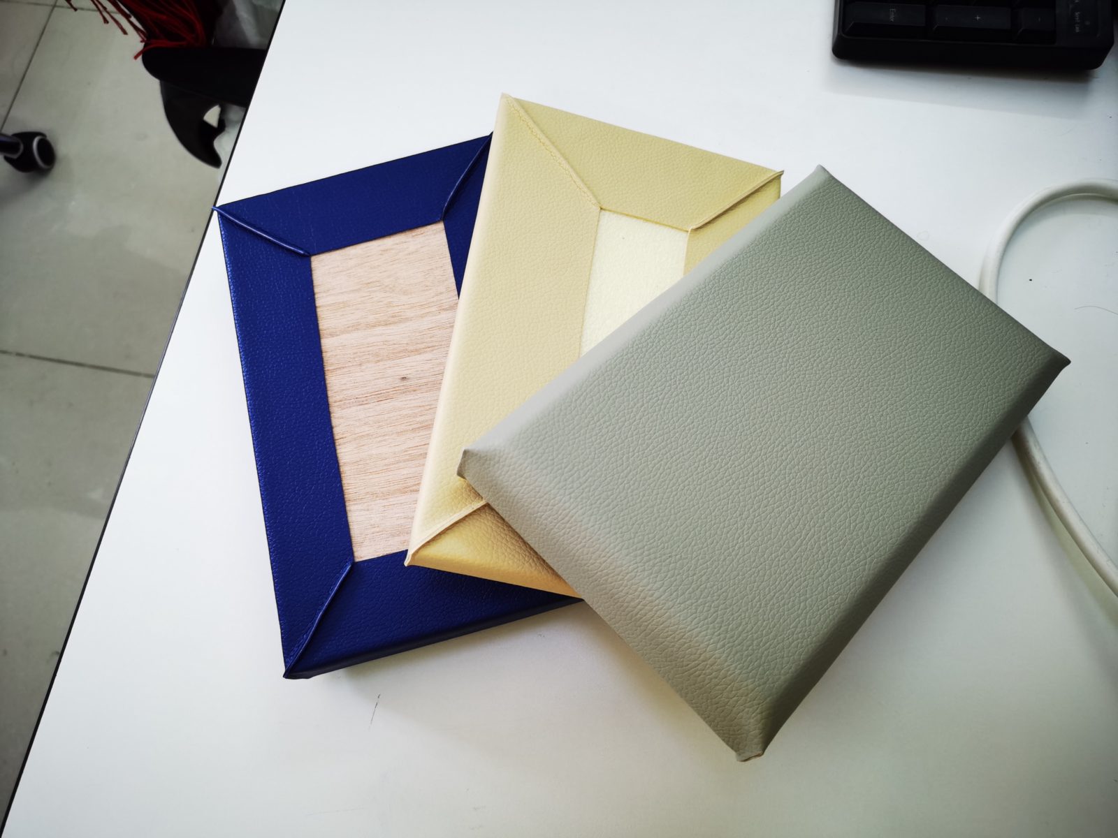 多种颜色皮革防撞软包墙板样品,展示木底板结构与包边工艺,用于办案区审讯室墙面防撞
