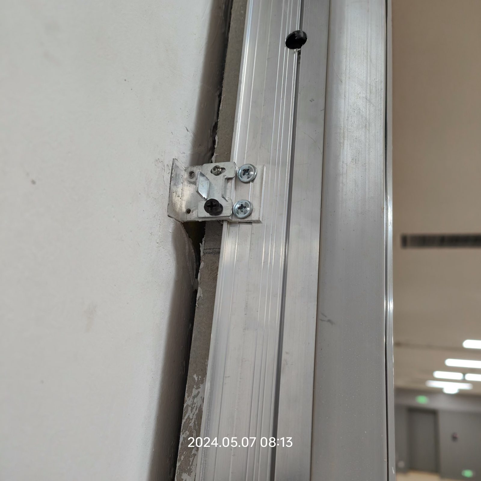 钢制防撞门框合页固定支架安装细节,螺丝固定门框与墙体连接结构特写