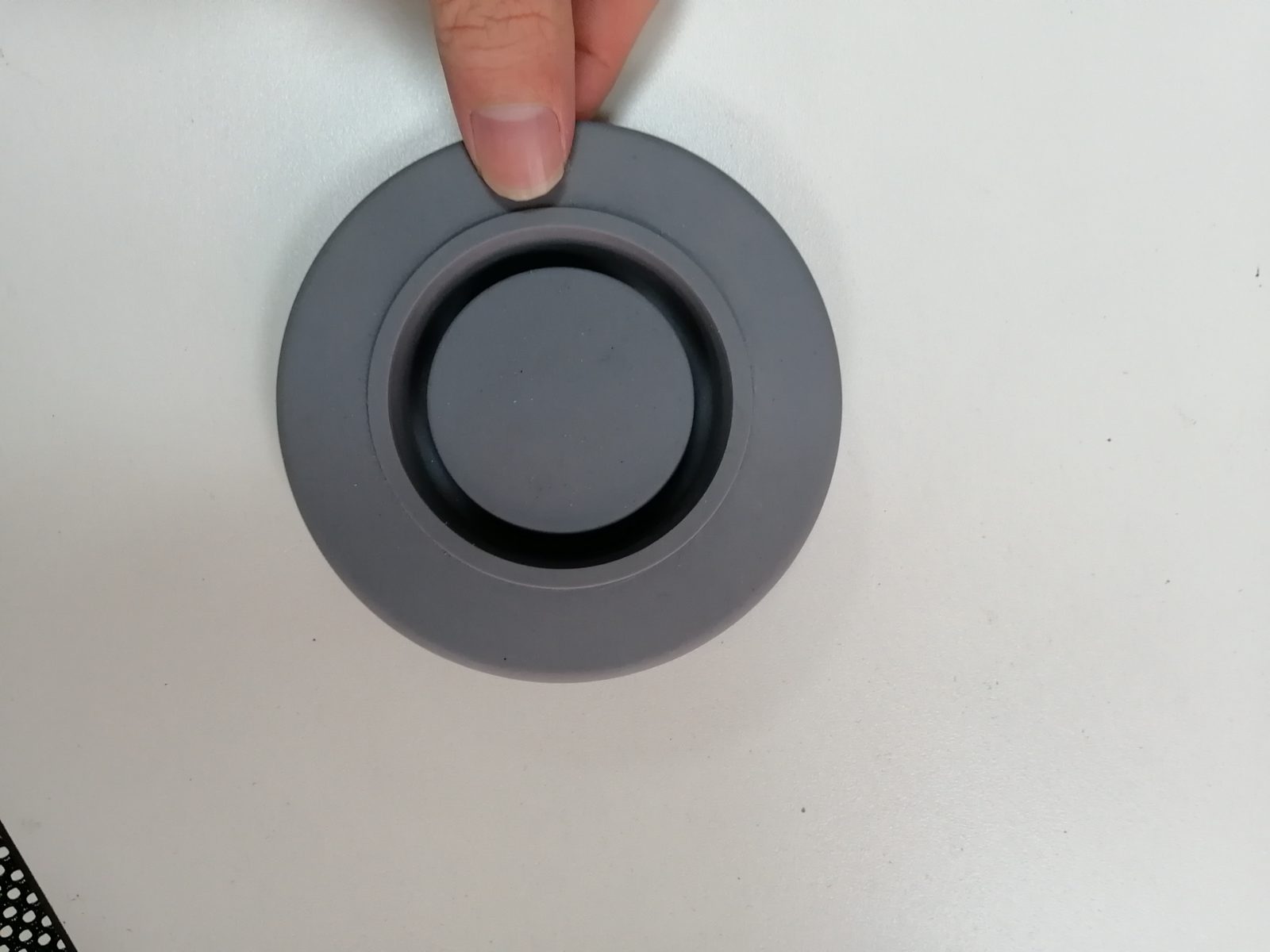 灰色圆形橡胶减震密封垫特写，弹性凹面环形结构，用于隔音门窗密封与设备减振降噪处理