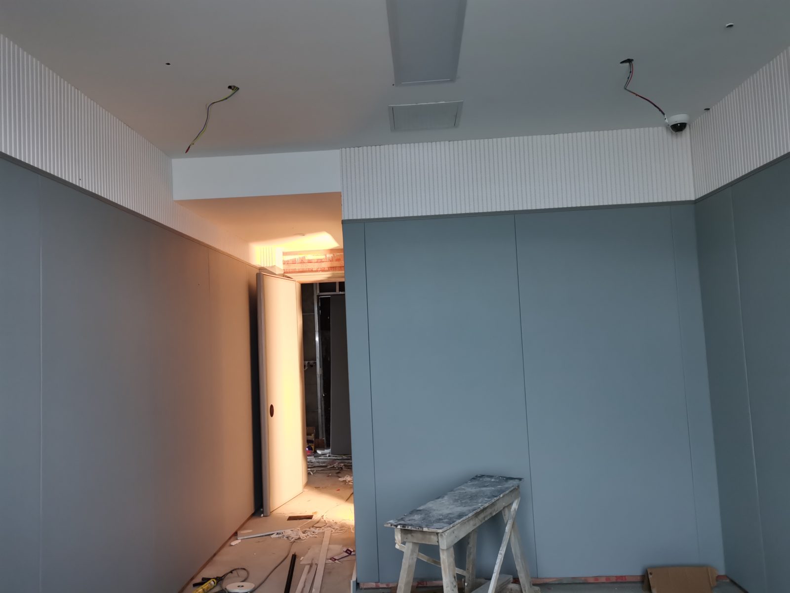 公检法办案区审讯室灰色防撞软包墙面与白色木条吸音板安装实景,高密度海绵软包防自伤设计