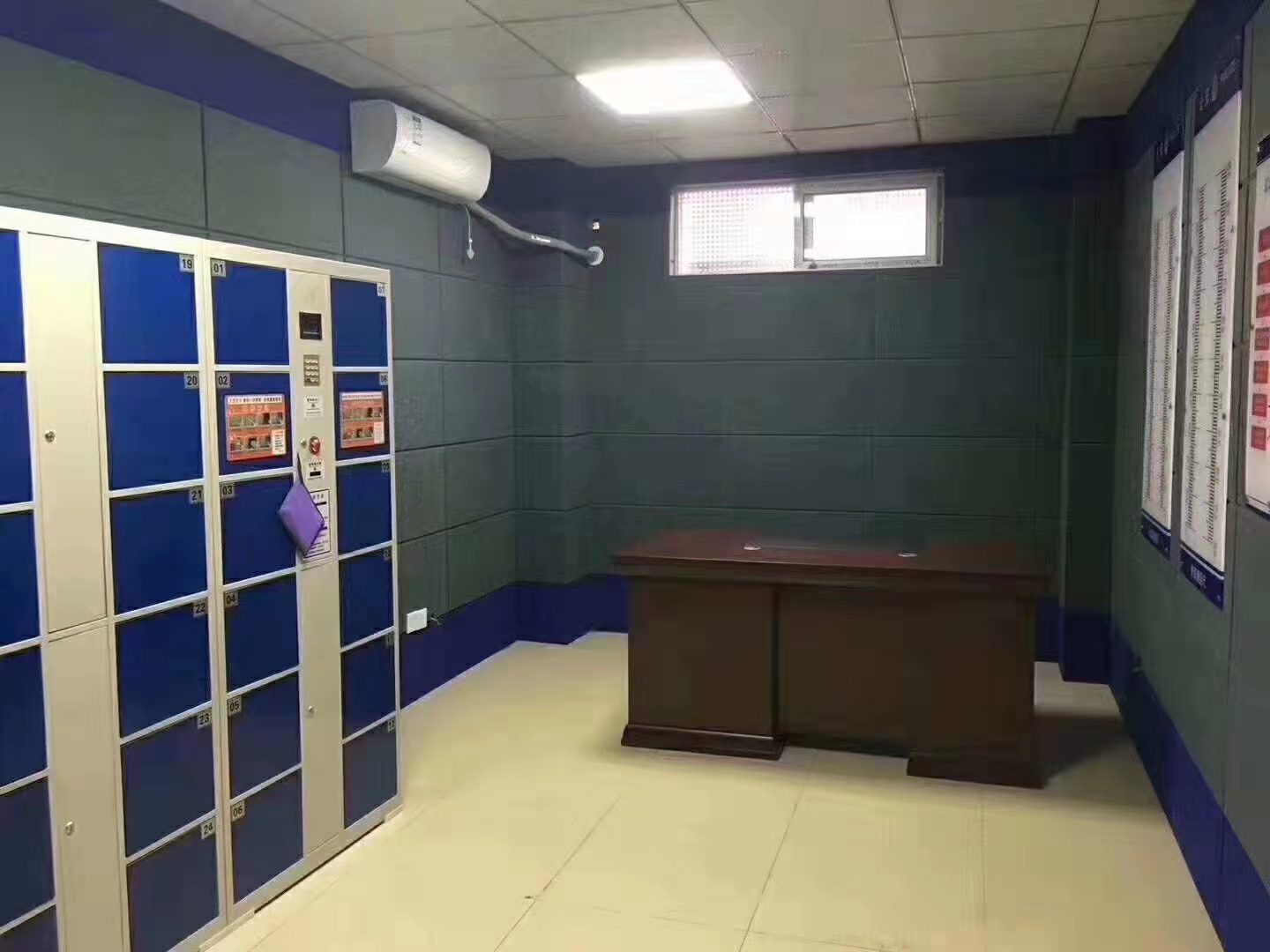 询问室深绿色防撞软包墙面整体装修实景,软包墙板搭配蓝色墙裙,适用于公检法办案区防撞防自伤
