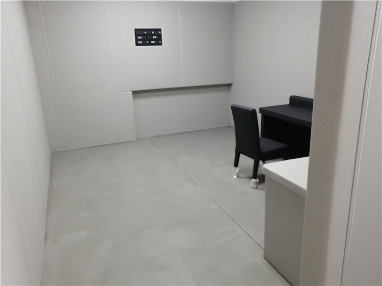 办案区询问室灰色防撞软包墙面整体装修实景,软包墙板搭配桌椅适用于审讯室防自伤设计