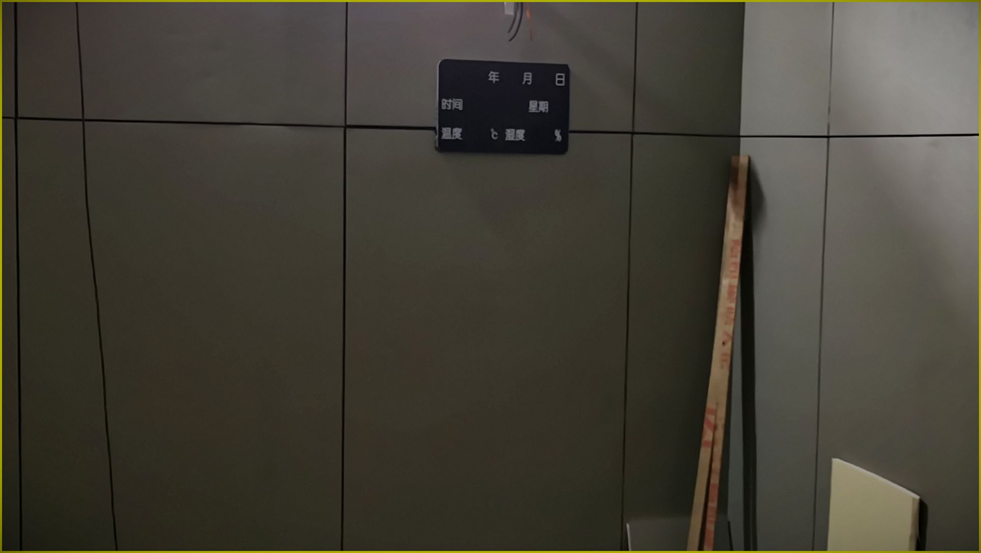 审讯室灰色防撞软包墙面安装实景,无缝软包墙板搭配电子时间温湿度显示屏,防自伤防撞处理