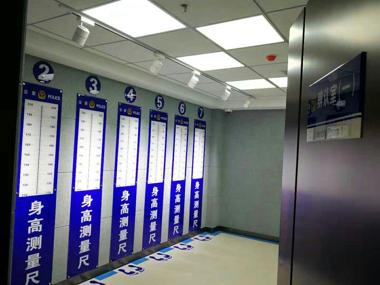 公安办案区辨认室灰色防撞软包墙面配身高测量尺装修实景，高密度海绵软包防自伤设计