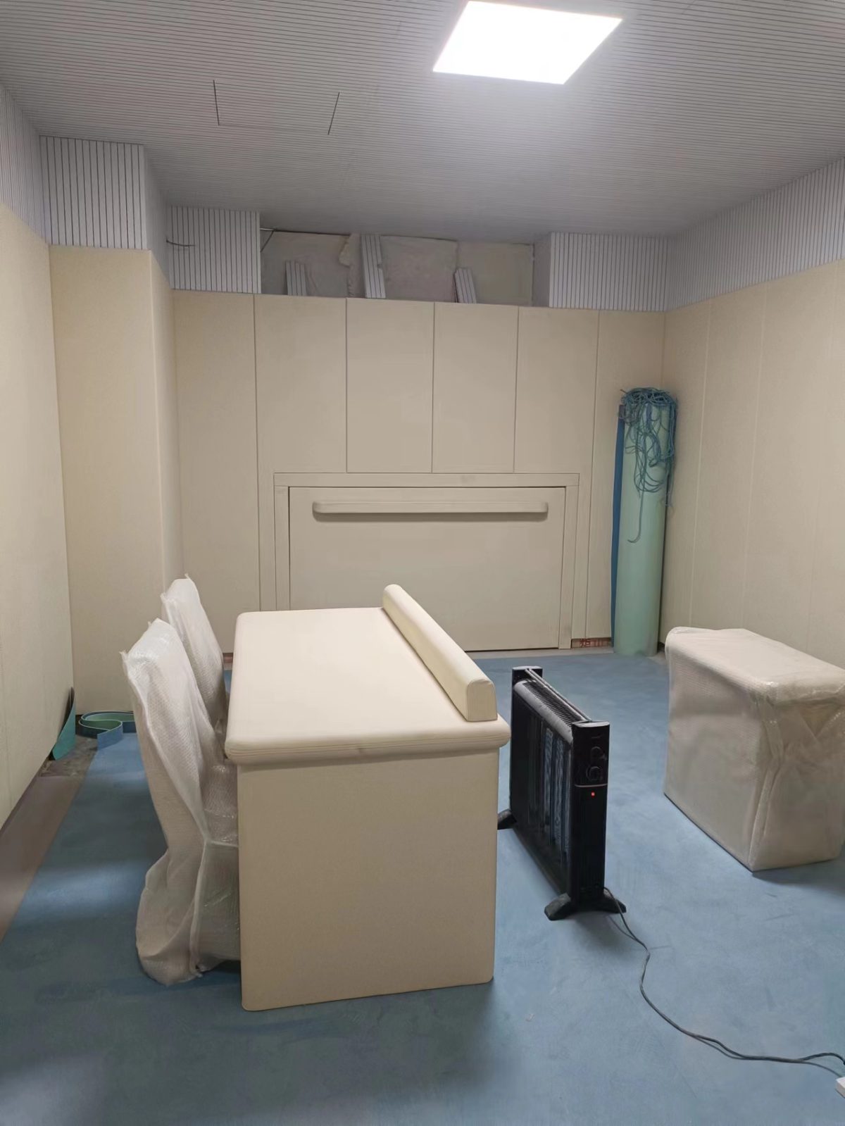 办案区询问室米色防撞软包墙面与防撞桌椅整体装修实景,高密度海绵软包防自伤设计