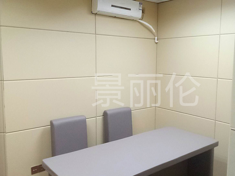 公安办案区询问室米色防撞软包墙面与灰色防撞桌椅整体实景,高密度海绵软包防自伤设计