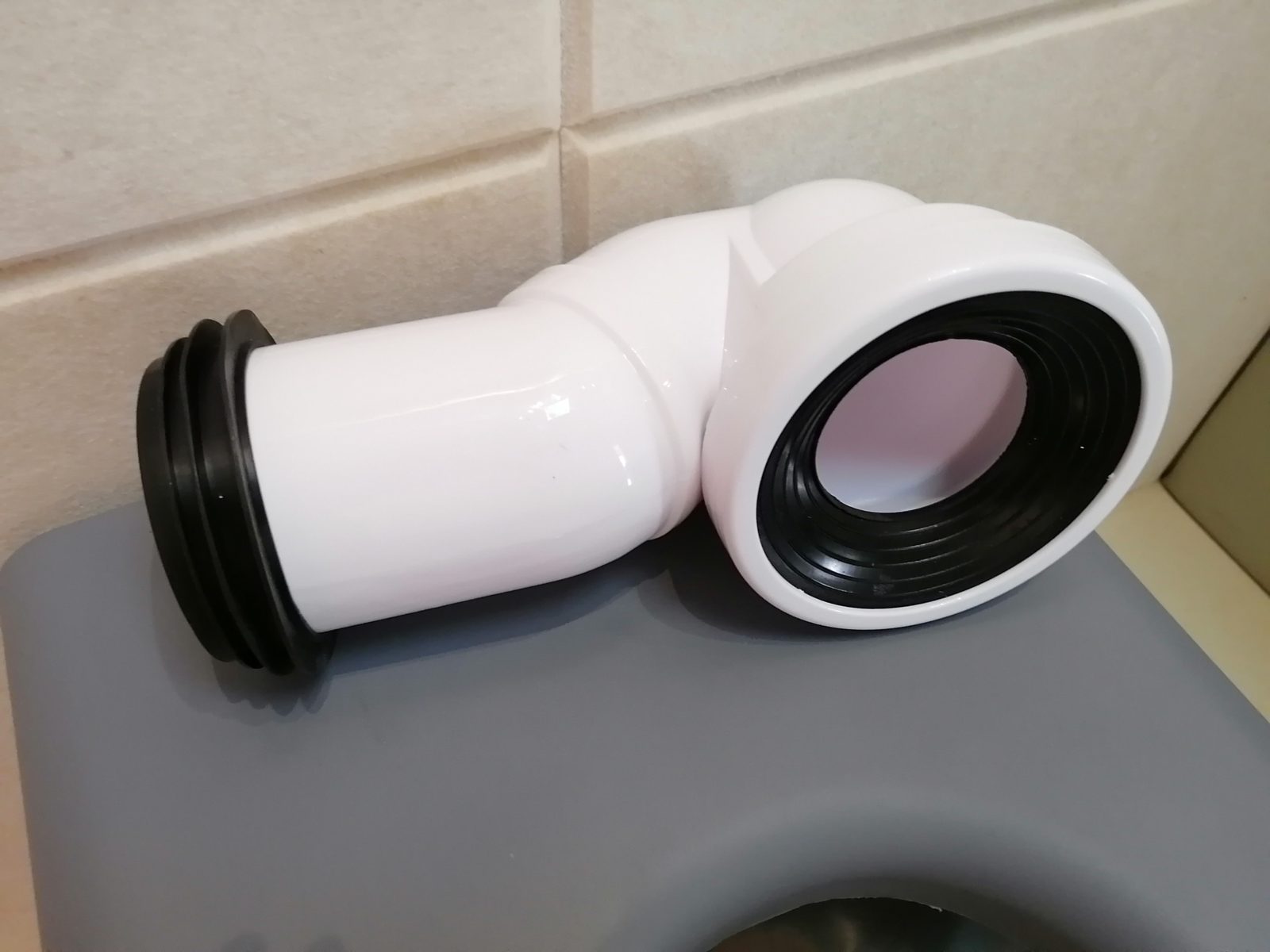 白色PVC马桶移位弯头连接器,两端配黑色橡胶密封圈,用于防撞马桶排污管移位密封连接安装