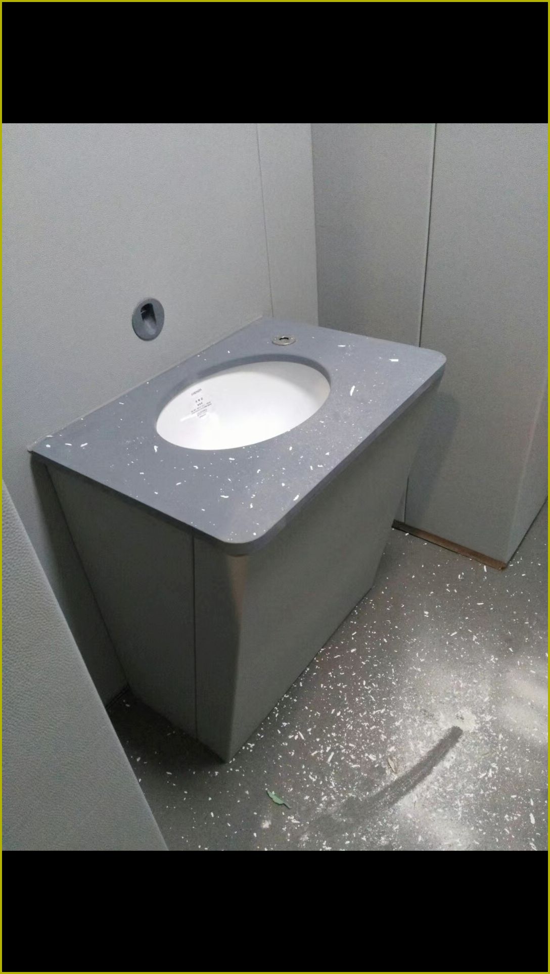 办案区审讯室防撞软包洗手台，灰色圆角石材台面嵌入陶瓷洗手盆，皮革软包柜体防自伤设计
