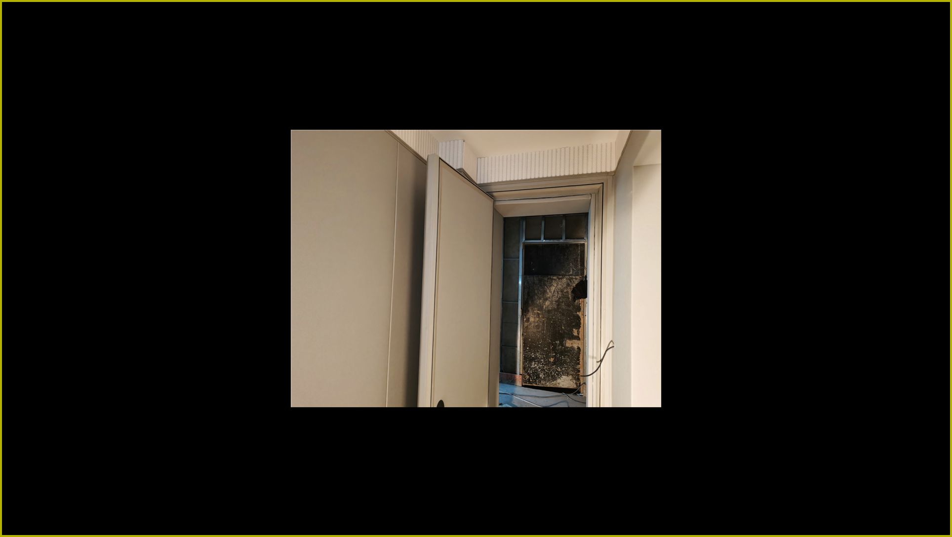 米白色钢制隔音门安装实景,厚重门扇配金属包边门框,适用于录音室机房等场所隔音降噪改造